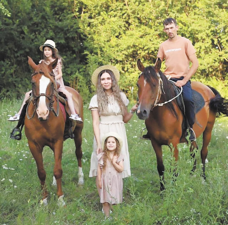 Семья Потапенко рядом с лошадьми Зорькой и Эврикой.